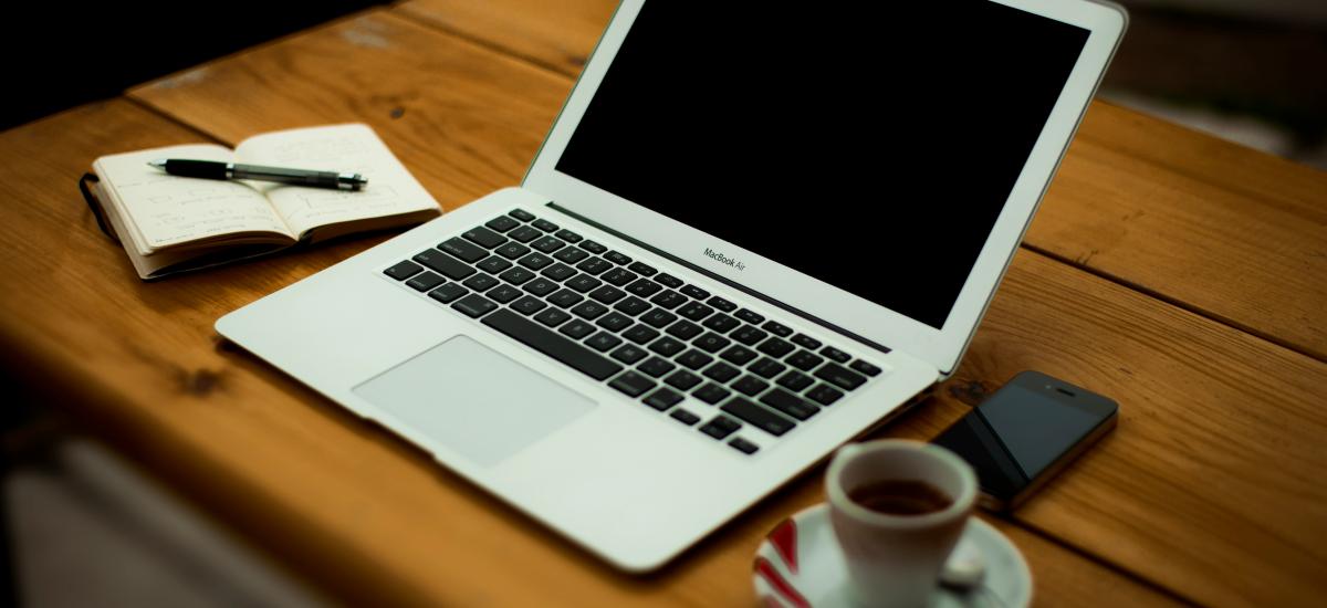 Laptop, coffee and notes ready to prepare a proposal
